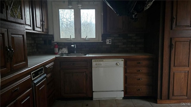 kitchen featuring dishwasher, tasteful backsplash, tile counters, and sink