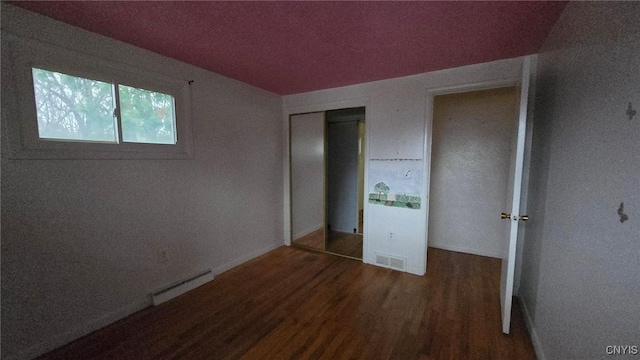 unfurnished bedroom featuring dark wood-type flooring and a closet