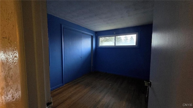 unfurnished room with dark hardwood / wood-style flooring and a textured ceiling