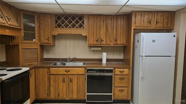 kitchen with a paneled ceiling, sink, and white appliances