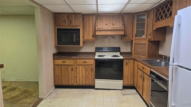 kitchen featuring a drop ceiling, white appliances, and sink