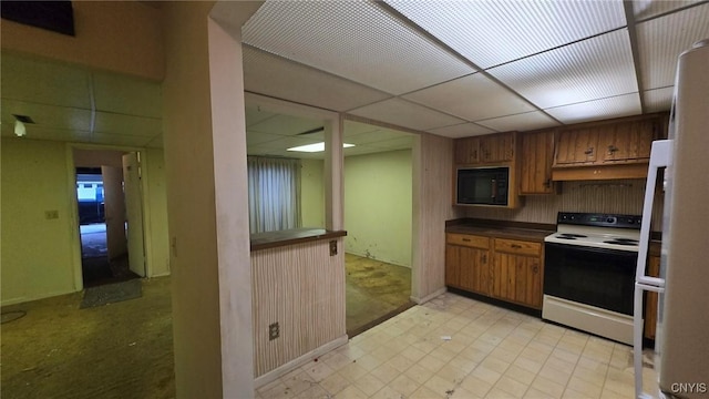 kitchen with white range with electric stovetop, a drop ceiling, and black microwave