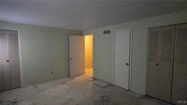 unfurnished bedroom with multiple closets