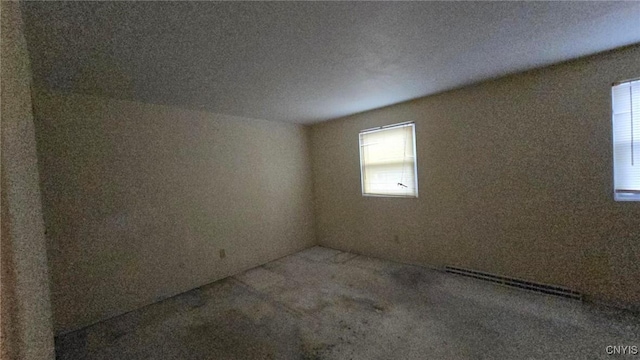 carpeted spare room featuring a baseboard radiator