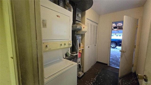 clothes washing area featuring stacked washing maching and dryer