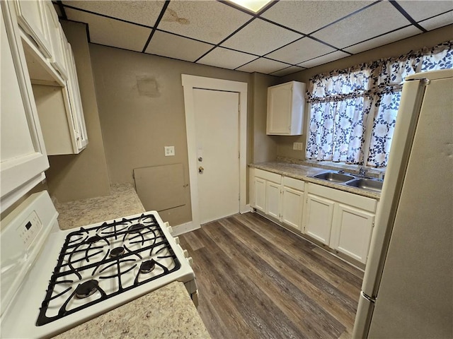 kitchen featuring a paneled ceiling, white appliances, dark wood-type flooring, white cabinets, and sink