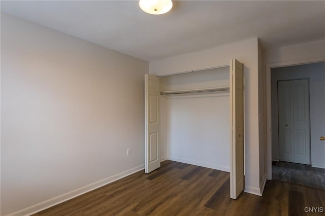 unfurnished bedroom with a closet and dark wood-type flooring