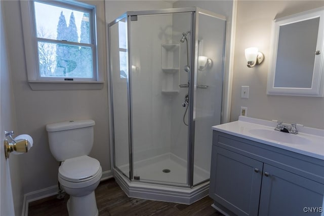 bathroom with wood-type flooring, vanity, toilet, and an enclosed shower