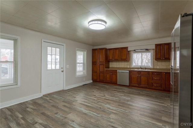 kitchen featuring sink, crown molding, decorative backsplash, dark hardwood / wood-style floors, and stainless steel appliances