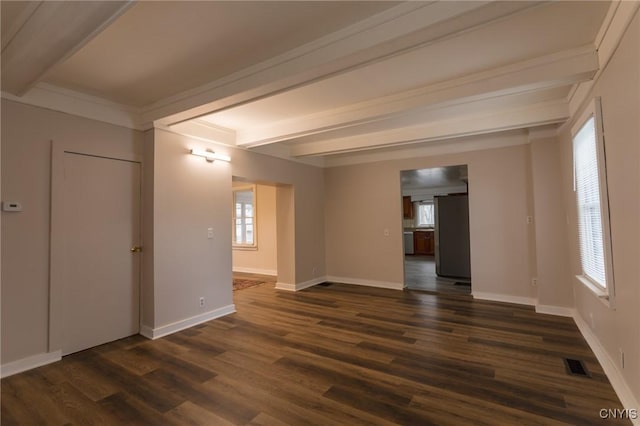 spare room featuring beamed ceiling and dark hardwood / wood-style floors