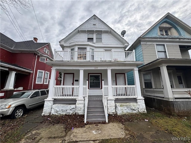 victorian-style house featuring a porch and a balcony