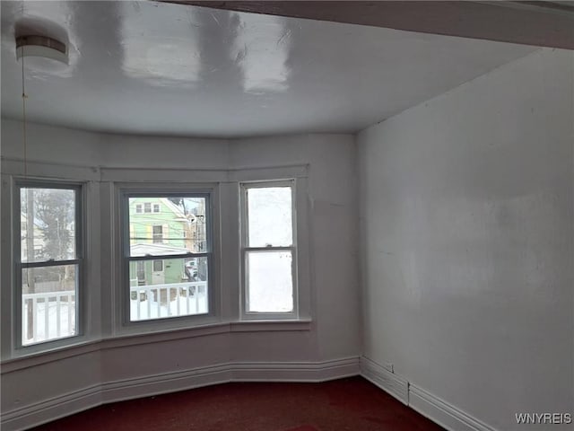 spare room with baseboards