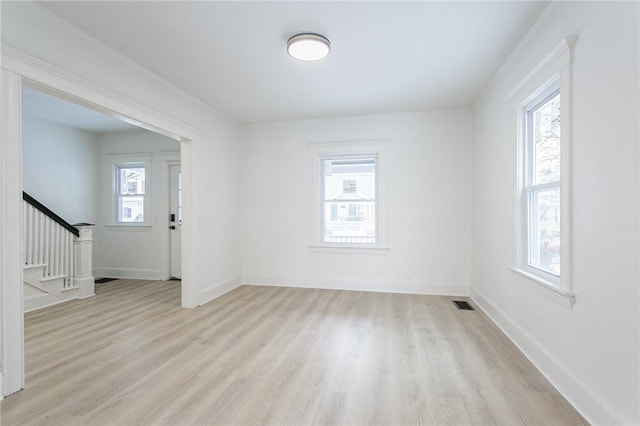 unfurnished room featuring a wealth of natural light and light wood-type flooring