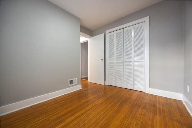 unfurnished bedroom featuring hardwood / wood-style floors and a closet