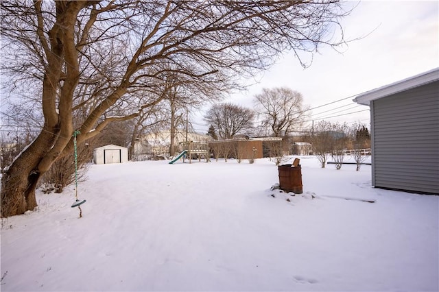 yard layered in snow with a shed