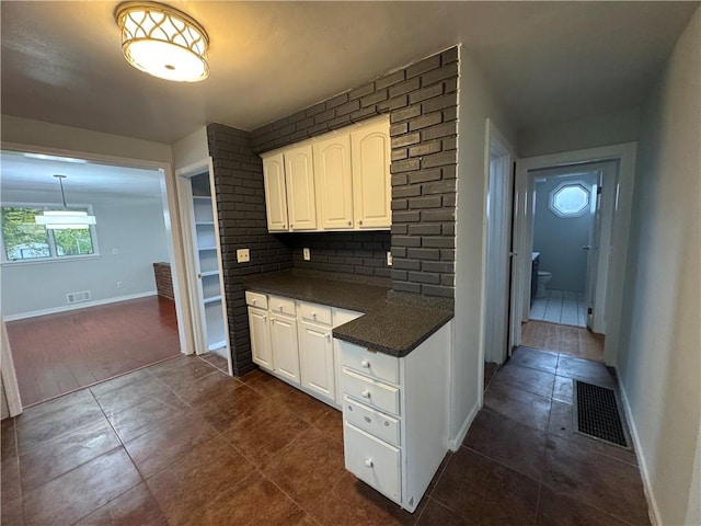 kitchen featuring tasteful backsplash, white cabinets, and pendant lighting