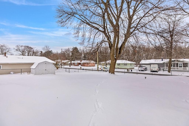 yard layered in snow with a storage shed