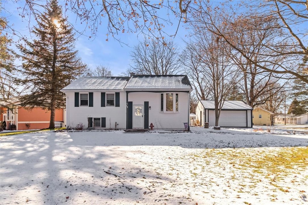 bi-level home with a garage and an outbuilding