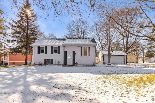 bi-level home with a garage and an outbuilding