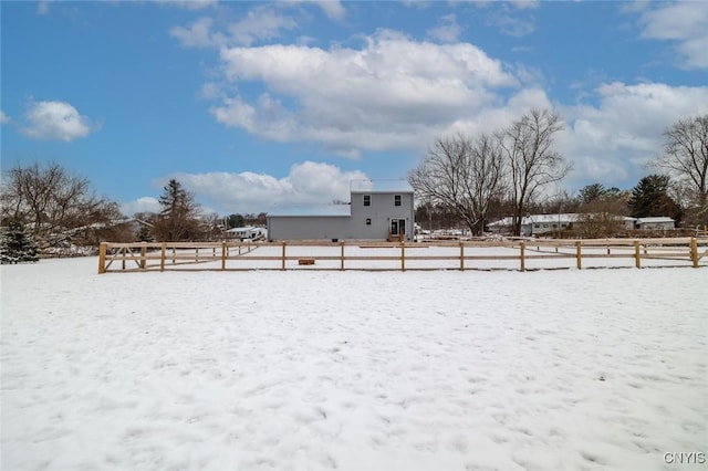 yard layered in snow with a rural view