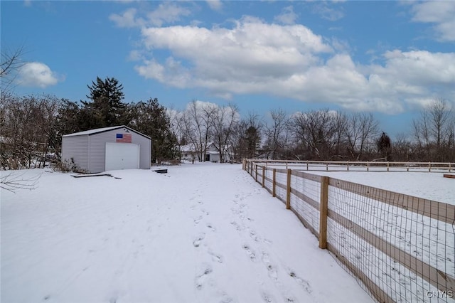 yard layered in snow with a garage and an outdoor structure