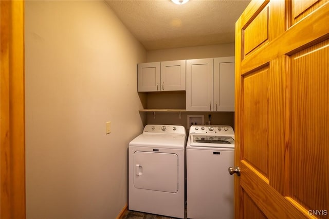 laundry area featuring washer and dryer, cabinets, and a textured ceiling