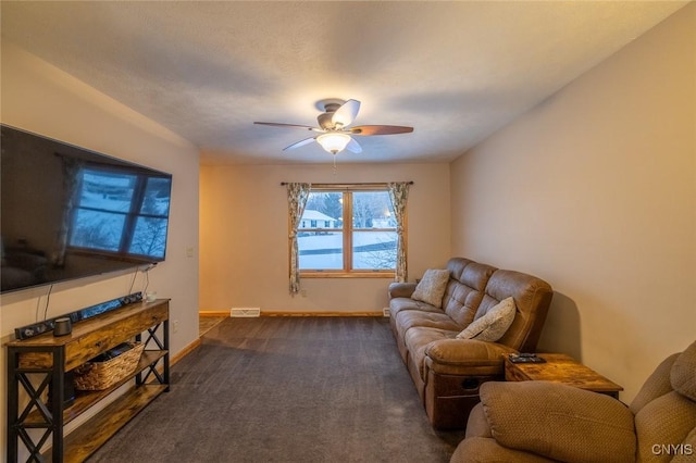 living room featuring ceiling fan and dark carpet