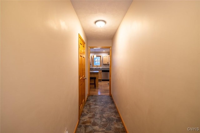 hallway featuring sink and a textured ceiling