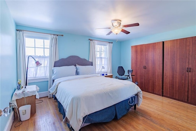 bedroom with multiple windows, light wood-type flooring, and ceiling fan