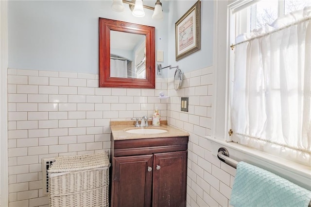 bathroom featuring vanity and tile walls