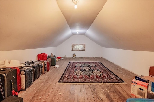 additional living space with hardwood / wood-style flooring and vaulted ceiling