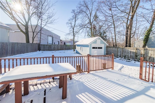 snow covered deck with a garage and an outbuilding