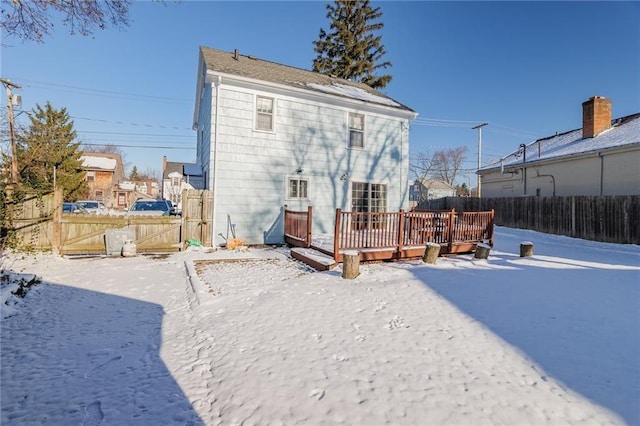 snow covered house featuring a deck