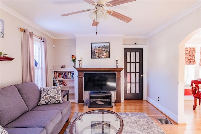 living room featuring ceiling fan, light hardwood / wood-style flooring, and ornamental molding