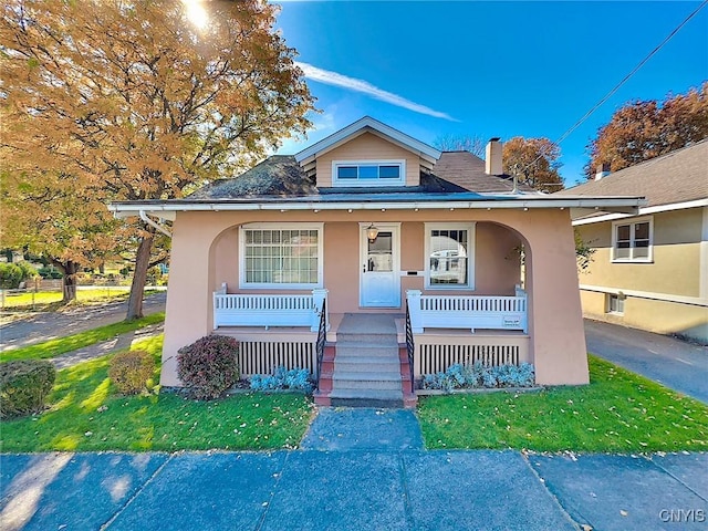 bungalow-style house featuring a porch and a front yard