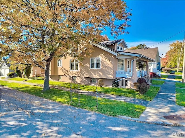 view of side of property featuring a porch and a lawn