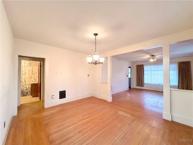 spare room featuring ceiling fan with notable chandelier and wood-type flooring