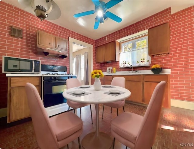 kitchen featuring ceiling fan, range, and sink