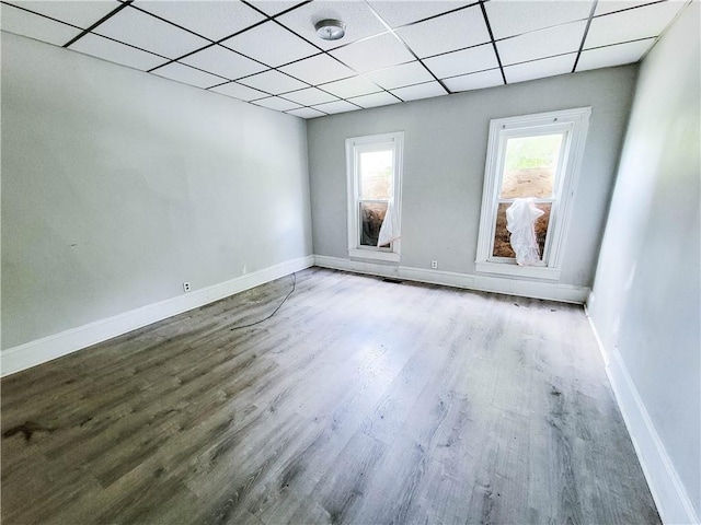 unfurnished room with a paneled ceiling and hardwood / wood-style flooring