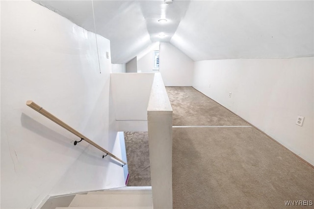 stairway featuring carpet flooring and lofted ceiling