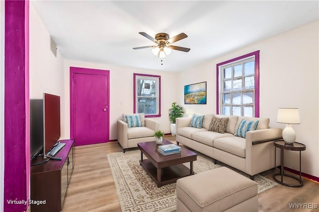 living room with ceiling fan, plenty of natural light, and light hardwood / wood-style floors