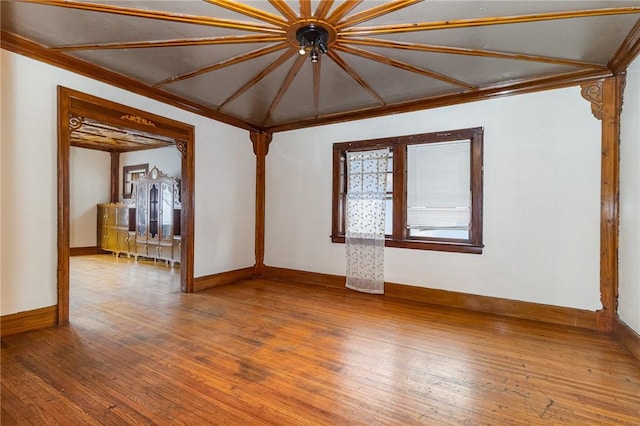 unfurnished living room with hardwood / wood-style floors and crown molding