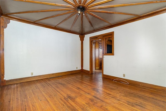 empty room featuring hardwood / wood-style flooring and crown molding