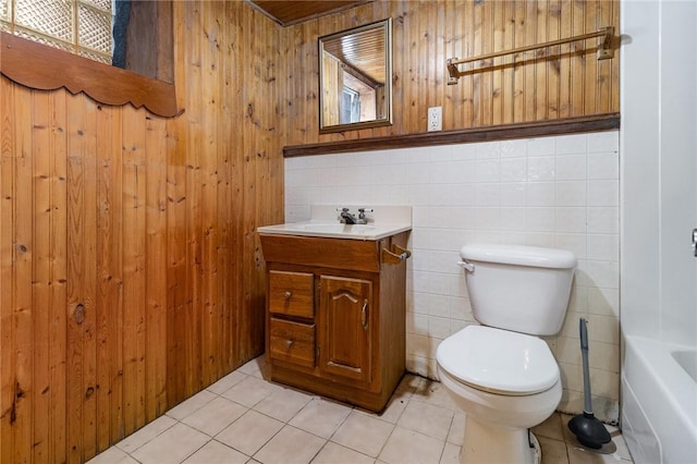 bathroom with tile patterned flooring, vanity, toilet, and a tub