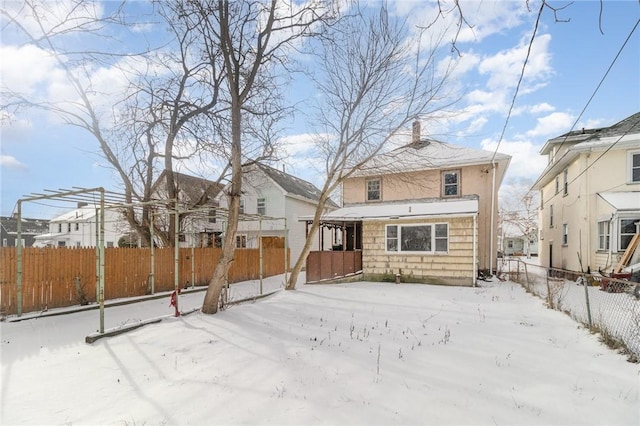 view of snow covered back of property