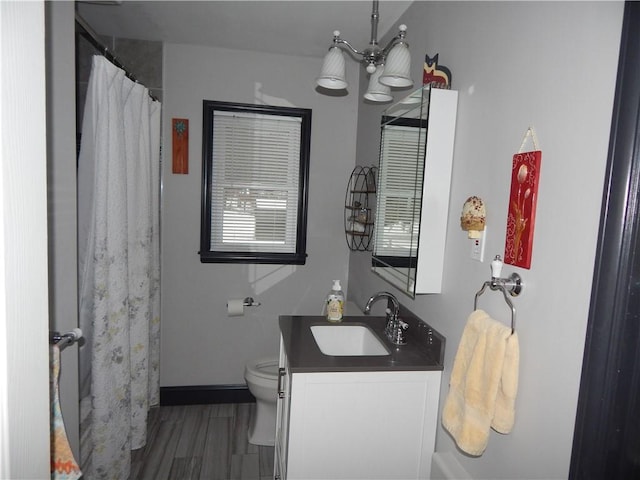 bathroom featuring toilet, vanity, and an inviting chandelier