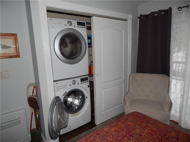 laundry area featuring stacked washer / drying machine