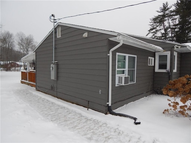 view of snow covered exterior with cooling unit