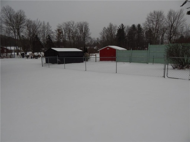 yard covered in snow with an outbuilding