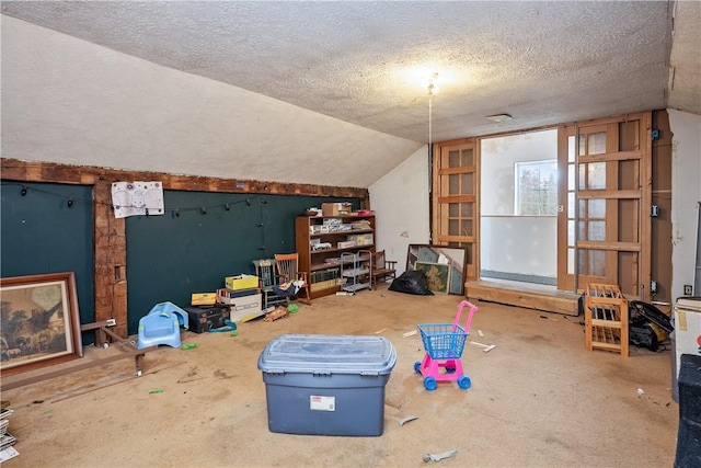 additional living space with a textured ceiling and lofted ceiling